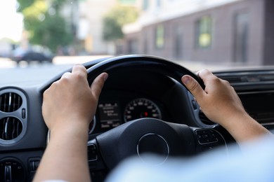Photo of Man driving car with steering wheel, closeup