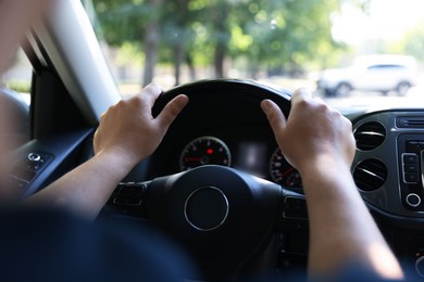 Photo of Man driving car with steering wheel, closeup