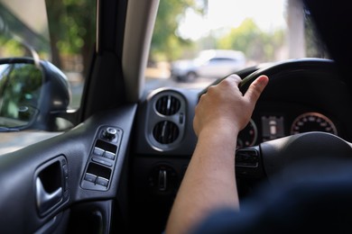 Photo of Man driving car with steering wheel, closeup