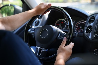 Photo of Man driving car with steering wheel, closeup