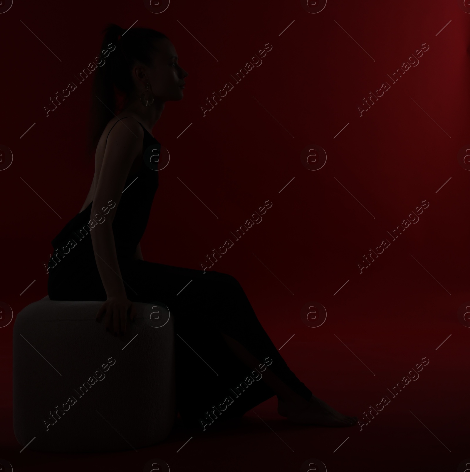 Photo of Silhouette of woman on dark red background, space for text