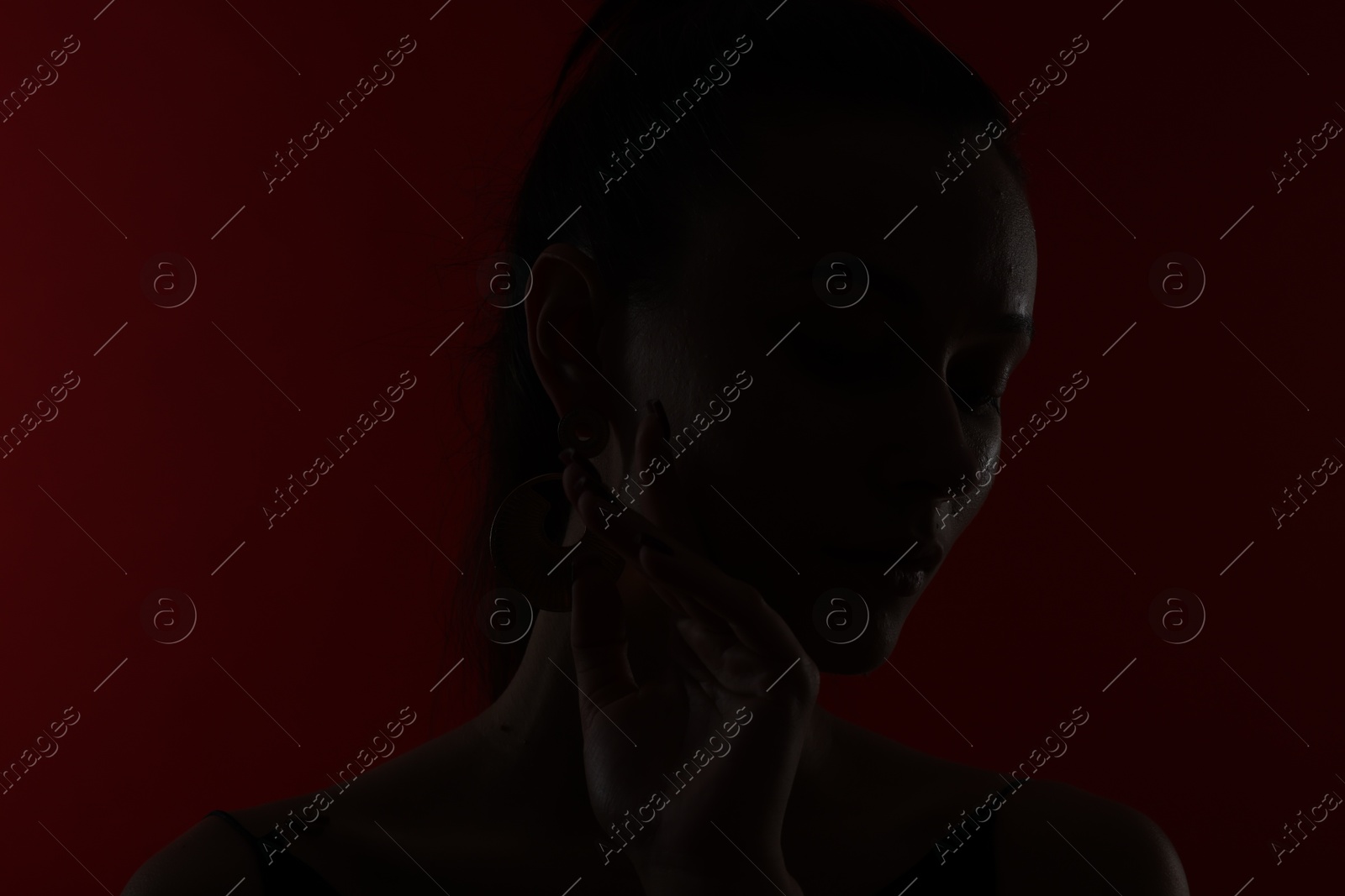 Photo of Silhouette of woman on dark red background