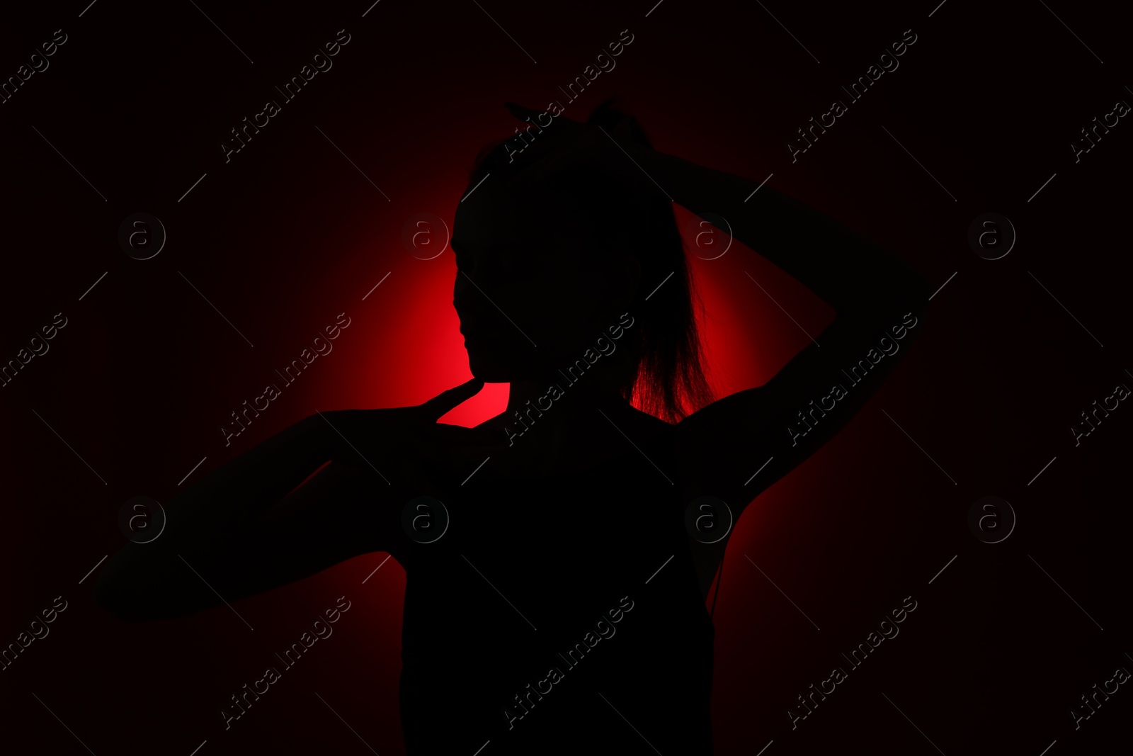 Photo of Silhouette of woman on dark red background