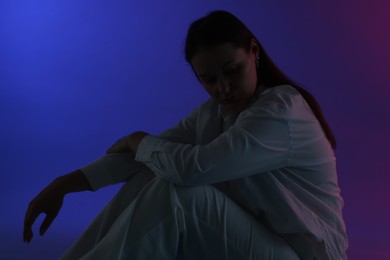 Photo of Beautiful young woman sitting on color background