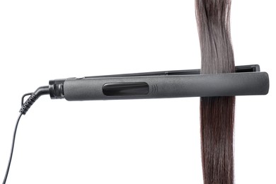 Photo of Straightener with brown hair lock isolated on white
