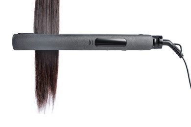 Photo of Straightener with brown hair lock isolated on white