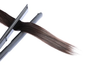 Photo of Straightener with brown hair lock isolated on white