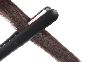 Photo of Straightener with brown hair lock isolated on white