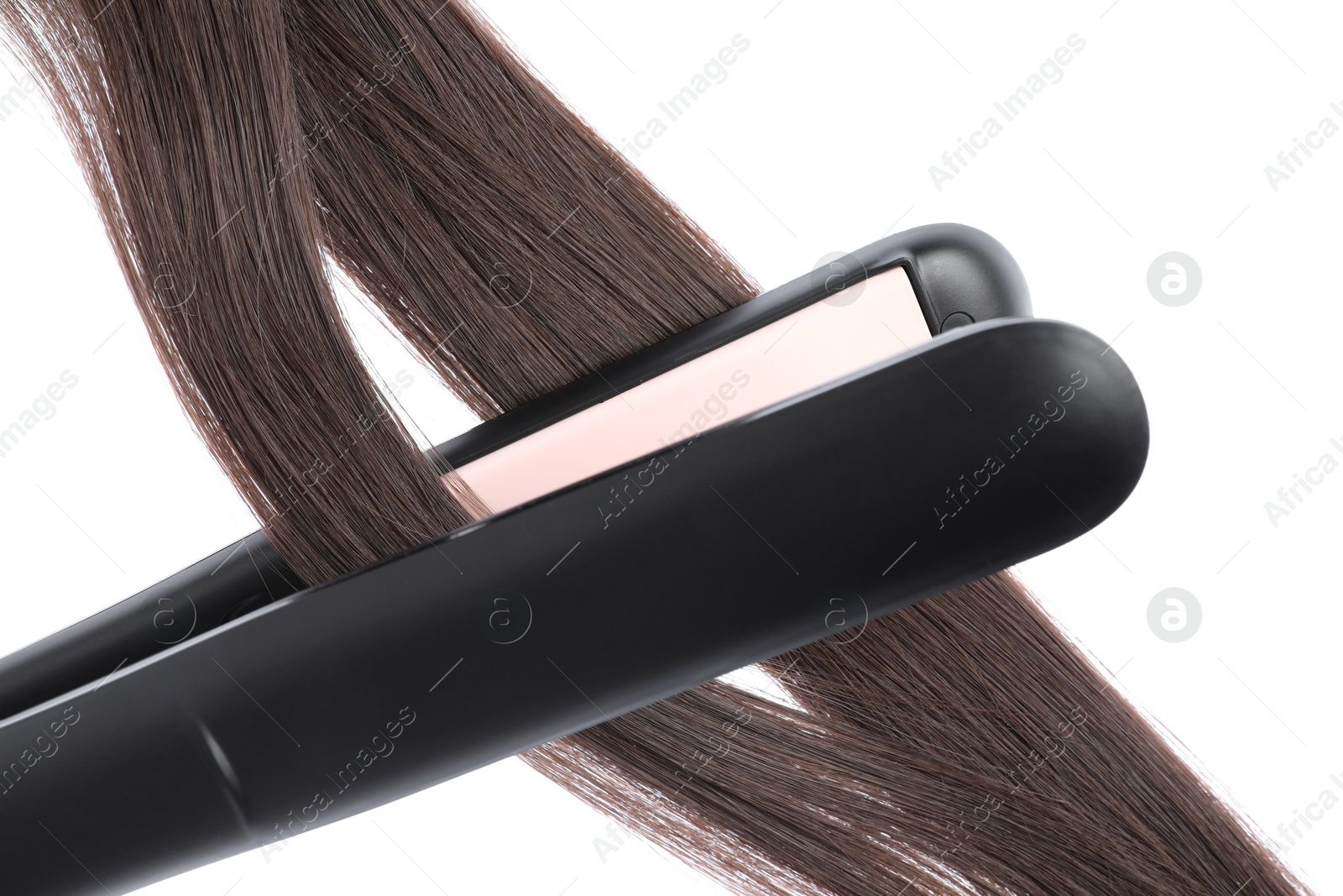 Photo of Straightener with brown hair locks isolated on white