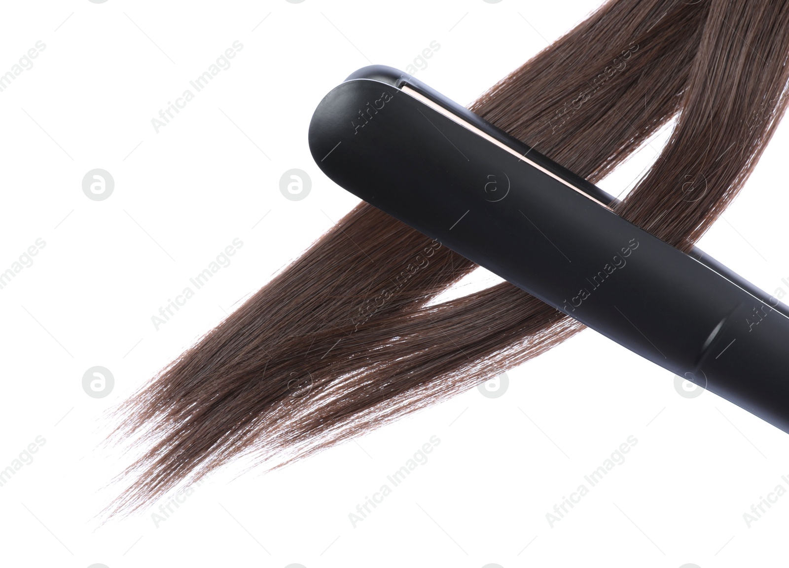 Photo of Straightener with brown hair locks isolated on white