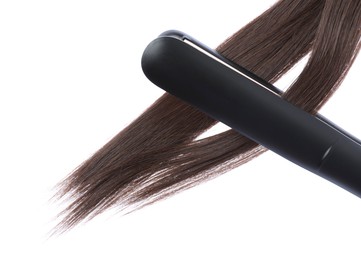 Photo of Straightener with brown hair locks isolated on white
