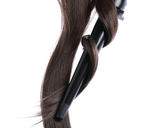 Photo of Curling iron with brown hair locks isolated on white
