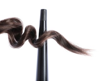 Photo of Curling iron with brown hair lock isolated on white