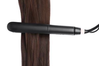 Photo of Straightener with brown hair lock isolated on white