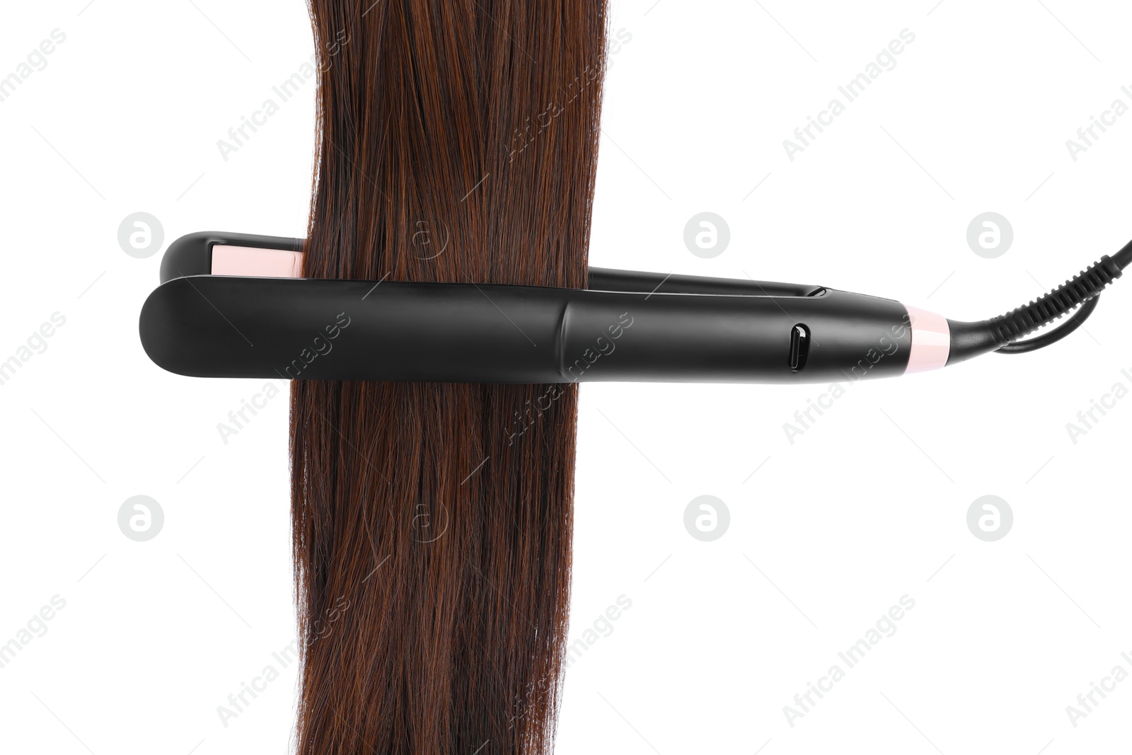 Photo of Straightener with brown hair lock isolated on white