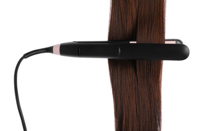 Photo of Straightener with brown hair lock isolated on white