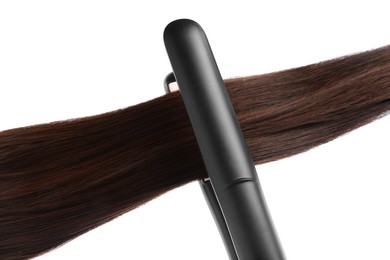 Photo of Straightener with brown hair lock isolated on white