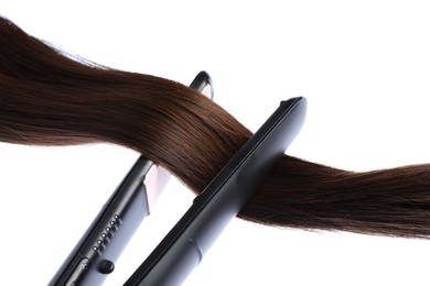 Photo of Straightener with brown hair lock isolated on white