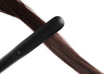 Photo of Straightener with brown hair lock isolated on white