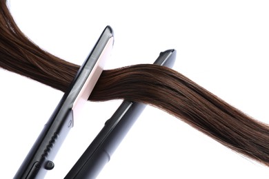 Photo of Straightener with brown hair lock isolated on white