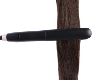 Photo of Straightener with brown hair lock isolated on white