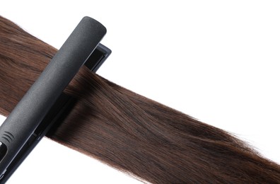 Photo of Straightener with brown hair lock isolated on white
