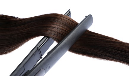 Photo of Straightener with brown hair lock isolated on white