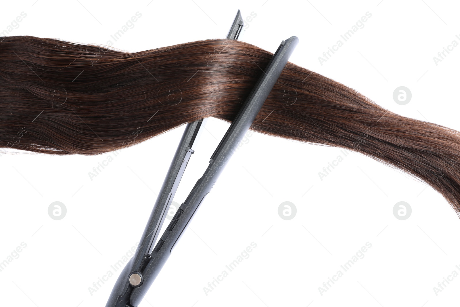 Photo of Straightener with brown hair lock isolated on white