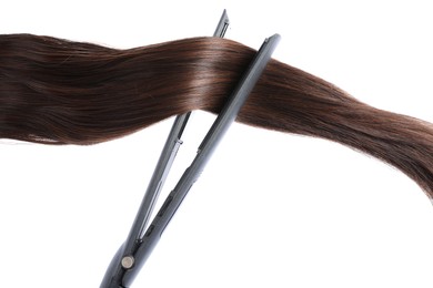 Photo of Straightener with brown hair lock isolated on white