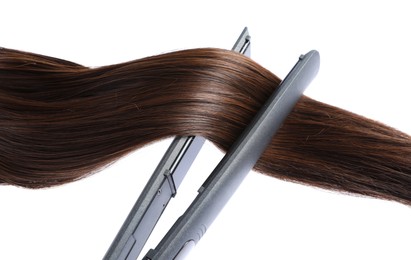 Photo of Straightener with brown hair lock isolated on white
