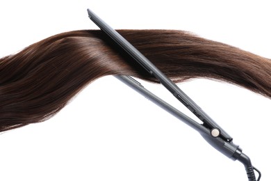 Photo of Straightener with brown hair lock isolated on white
