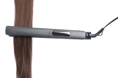 Photo of Straightener with brown hair lock isolated on white