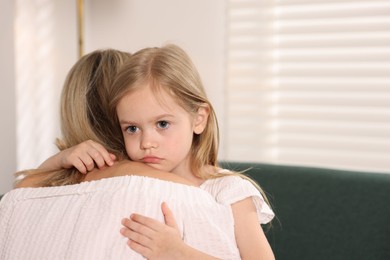 Photo of Daughter hugging her mother after apology at home. Space for text