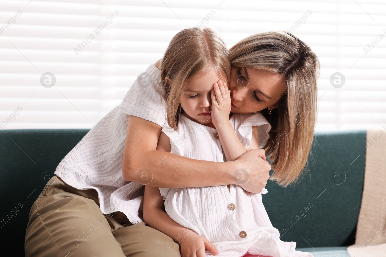Mother apologizing to her crying daughter on sofa at home Photo of Mother apologizing to her crying daughter on sofa at home