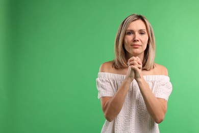 Photo of Woman apologizing on green background. Space for text