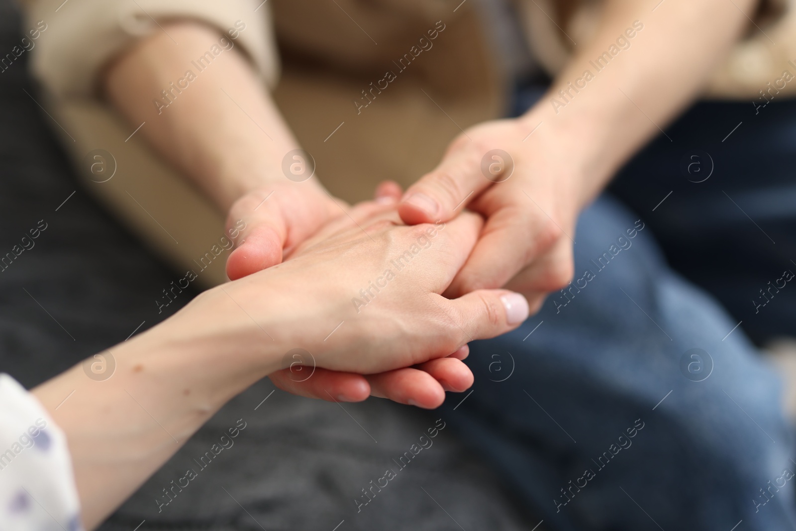 Photo of Couple holding hands after apology indoors, closeup