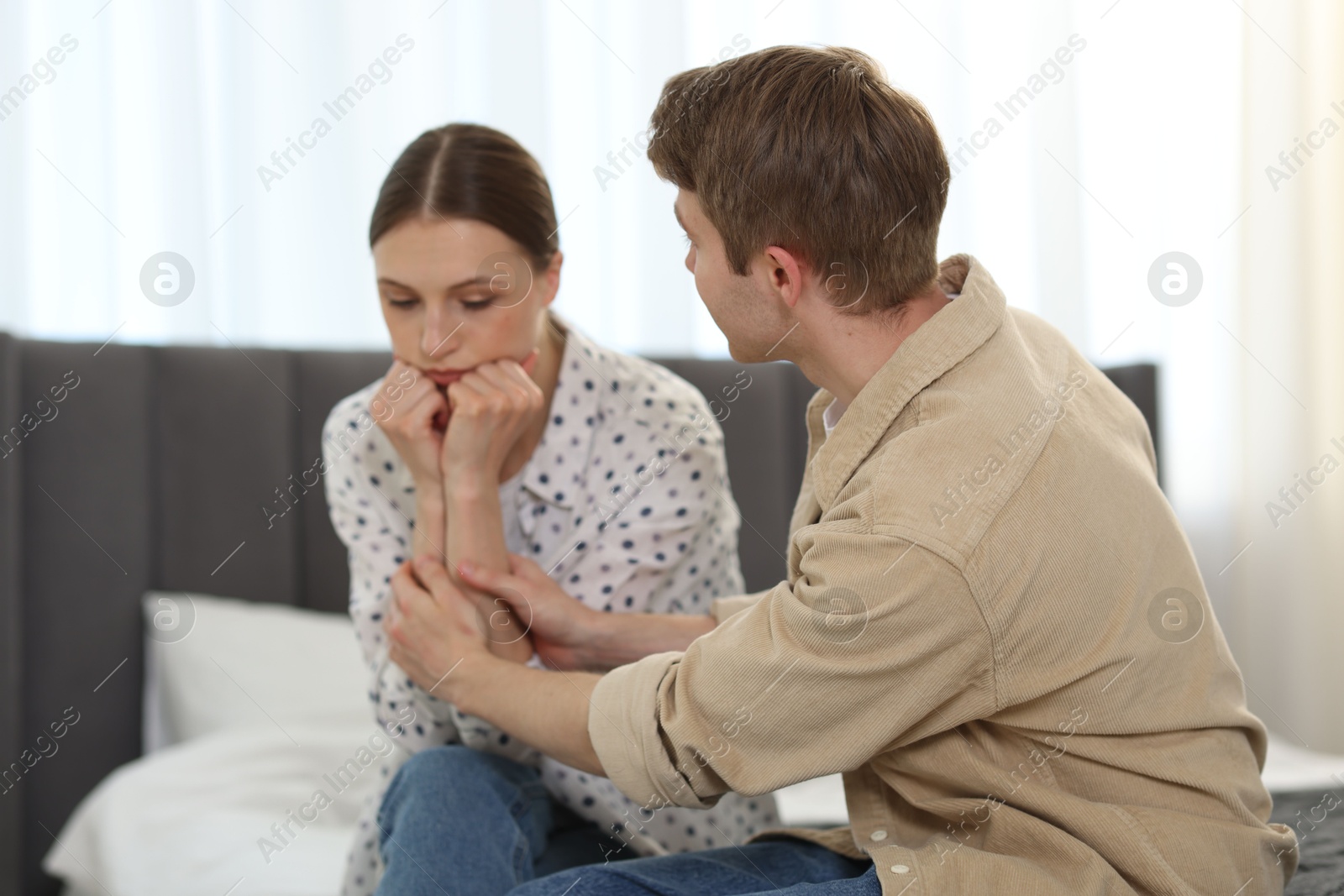 Man apologizing to his offended girlfriend on bed at home Photo of Man apologizing to his offended girlfriend on bed at home