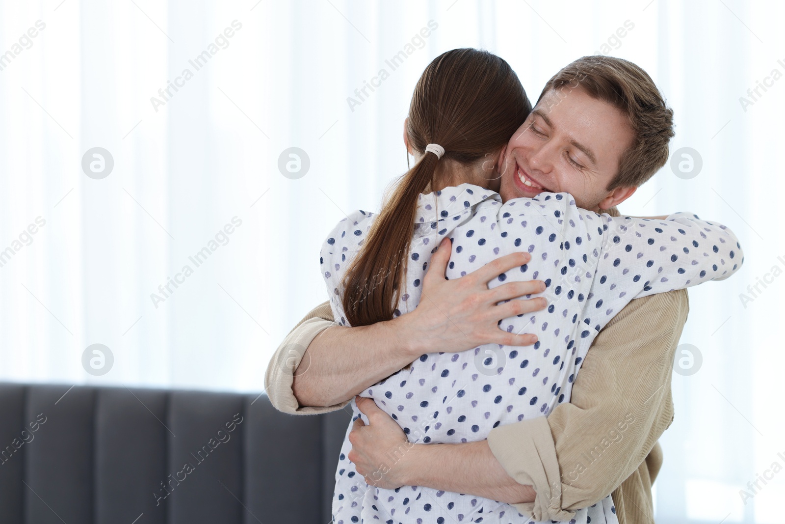 Happy couple hugging after apology at home. Space for text Photo of Happy couple hugging after apology at home. Space for text