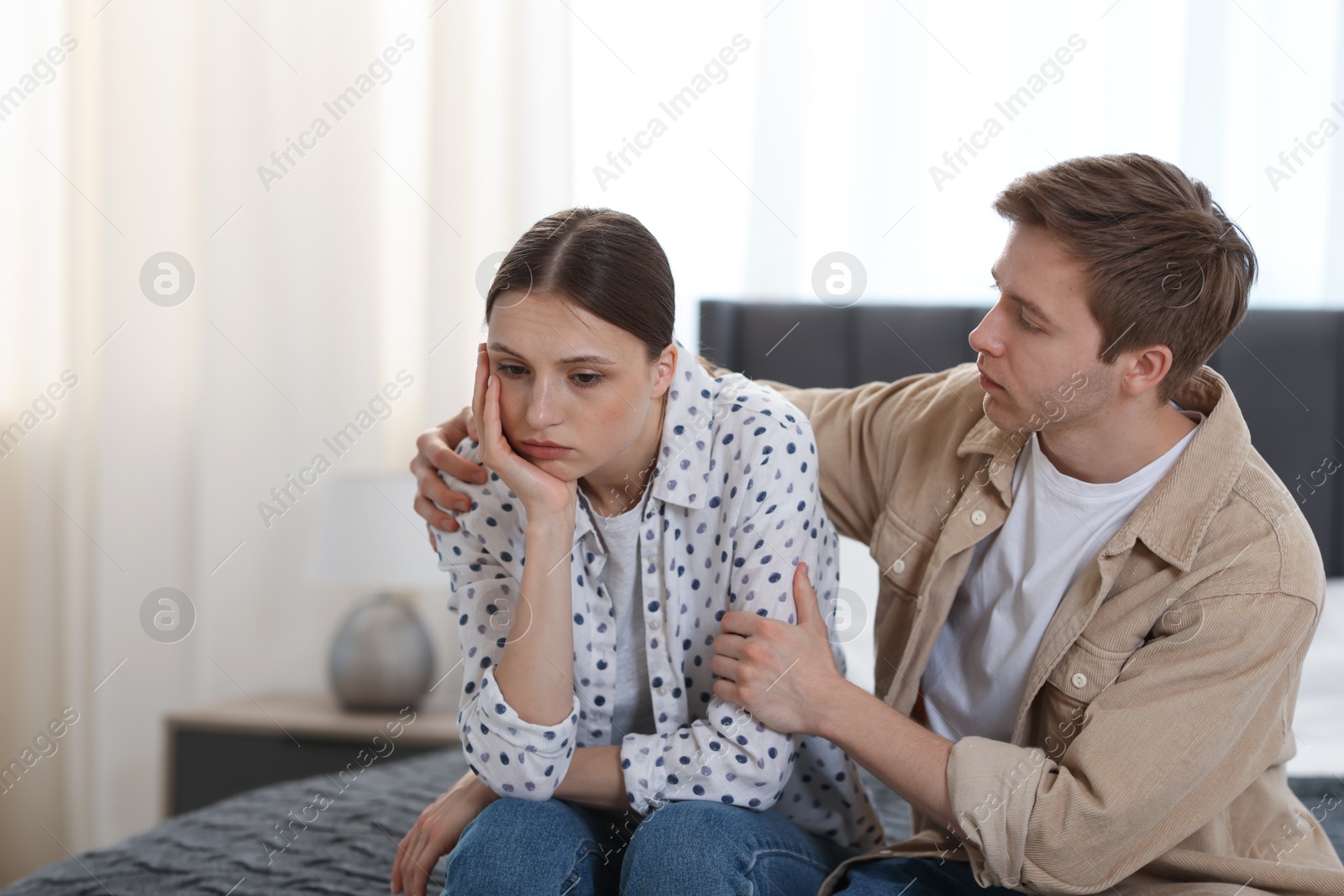 Man apologizing to his offended girlfriend on bed at home Photo of Man apologizing to his offended girlfriend on bed at home