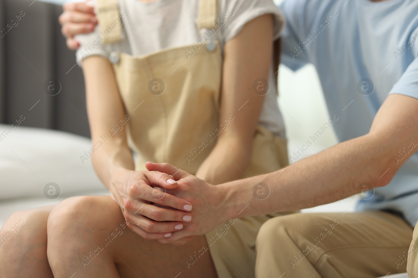 Photo of Couple holding hands after apology indoors, closeup