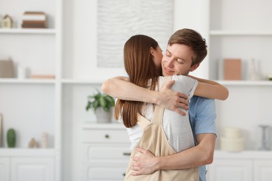 Photo of Happy couple hugging after apology at home. Space for text