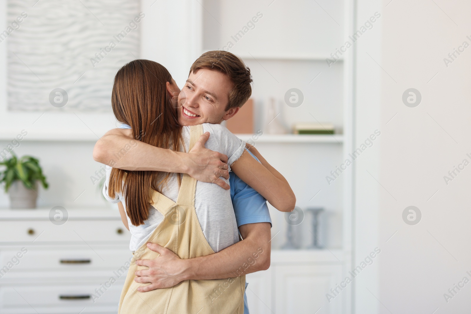 Photo of Happy couple hugging after apology at home. Space for text