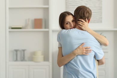 Photo of Couple hugging after apology at home. Space for text