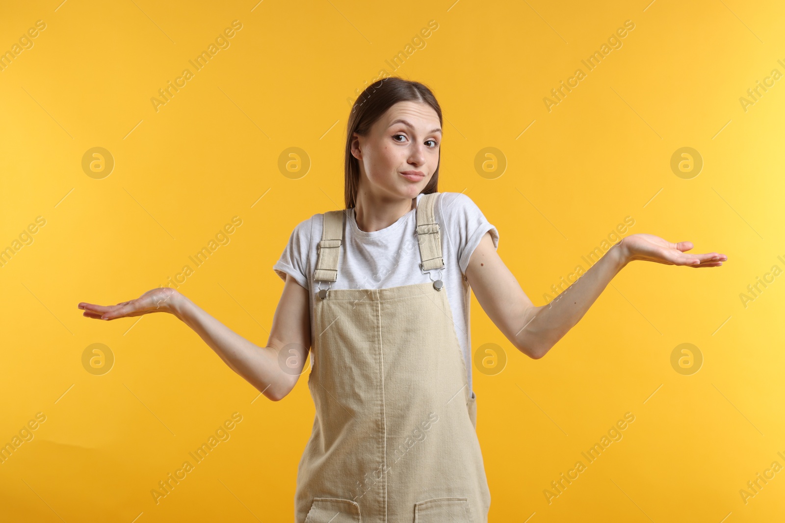 Photo of Portrait of confused woman apologizing on yellow background