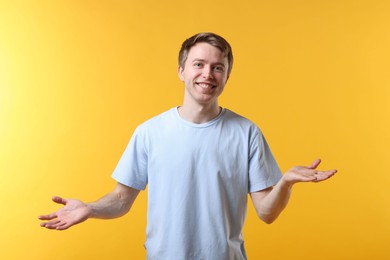 Photo of Portrait of smiling man apologizing on yellow background