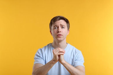 Photo of Portrait of man apologizing on yellow background