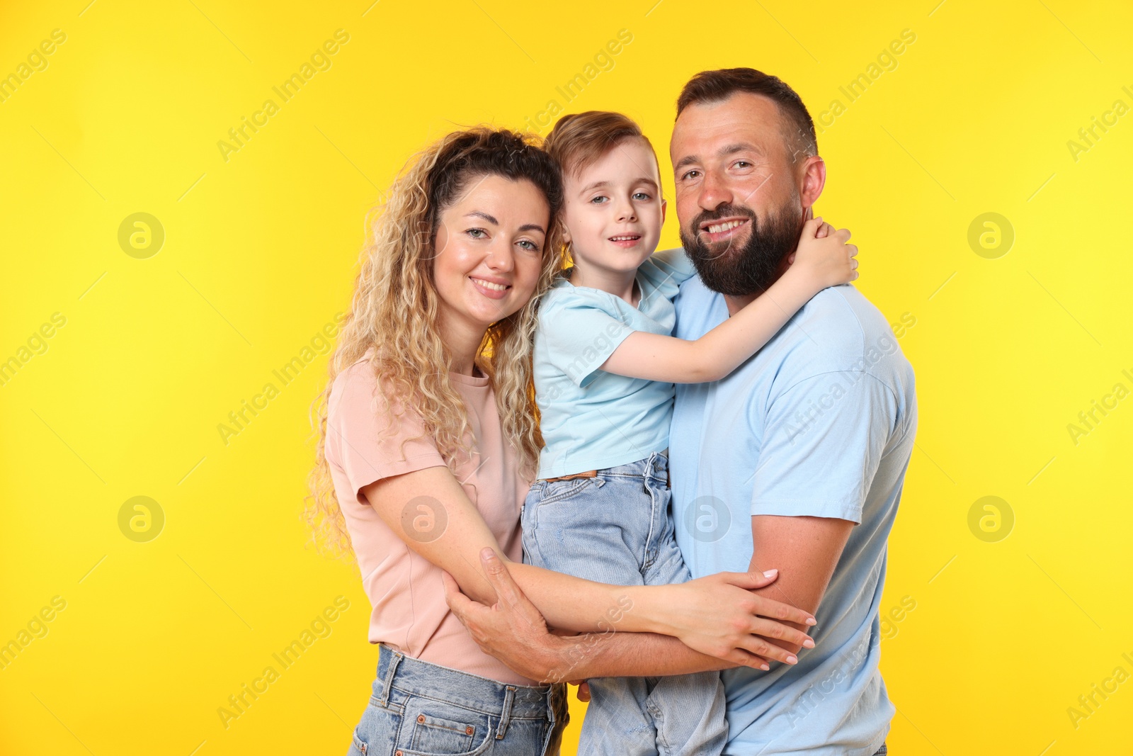 Portrait of happy family on yellow background Photo of Portrait of happy family on yellow background