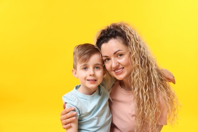 Photo of Family. Happy mother and her son on yellow background. Space for text