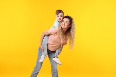 Photo of Family. Happy mother and her son on yellow background