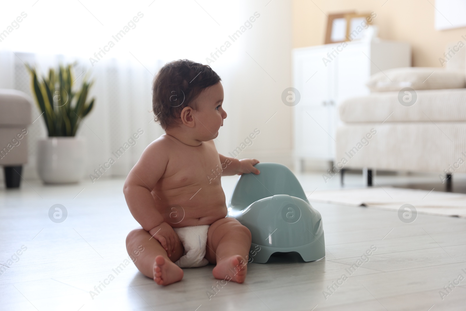 Cute little baby with potty on floor at home Photo of Cute little baby with potty on floor at home